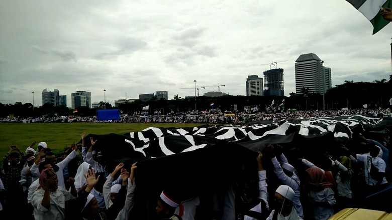 Bendera Hitam Raksasa Diarak di Depan Monas dengan Tertib