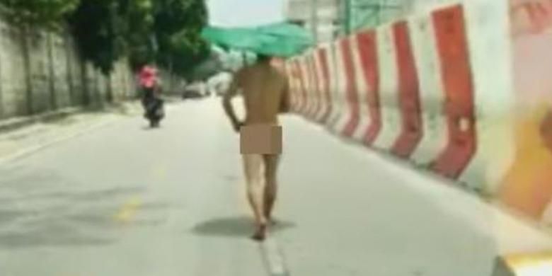 bikin-heboh-lelaki-tanpa-busana-berpayung-jalan-kaki-di-tengah-jalan