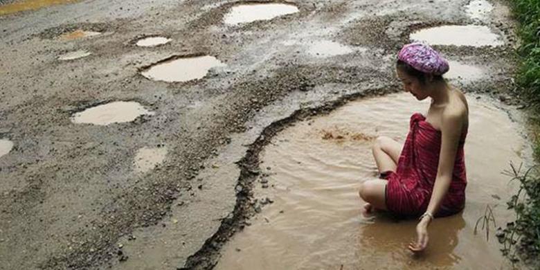 protes-jalan-rusak-model-cantik-berbalut-kain-mandi-di-kubangan-air-lumpur