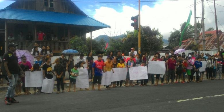 Warga Minahasa Berdiri di Pinggir Jalan Tunggu Kedatangan Jokowi