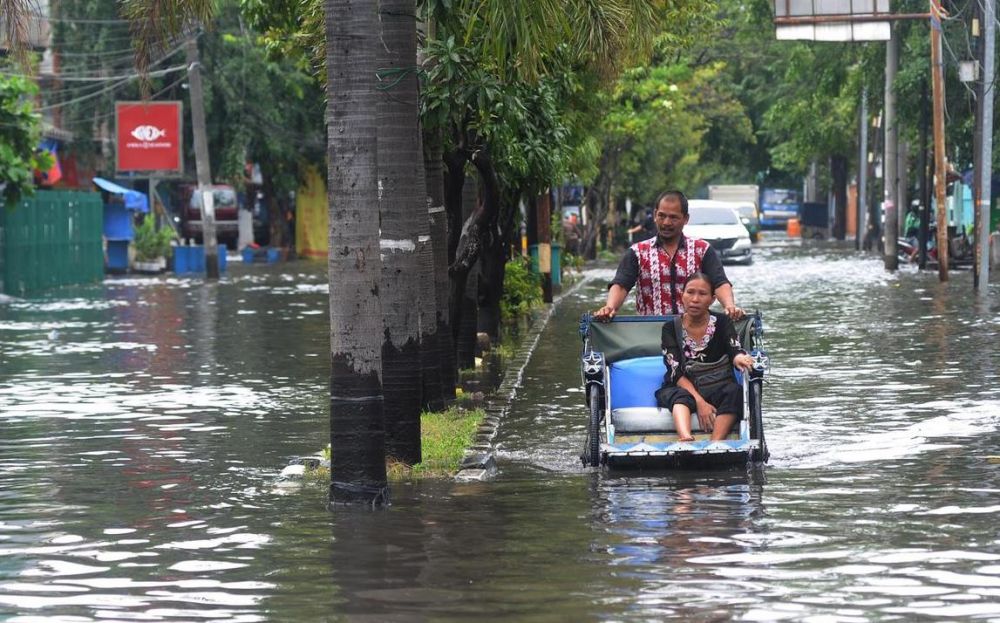 Potret tetap semangat bekerja di tengah banjir Jakarta, bikin kamu geleng kepala