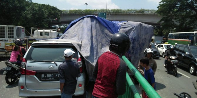 Hindari ojek online lawan arah, truk molen terguling timpa Avanza